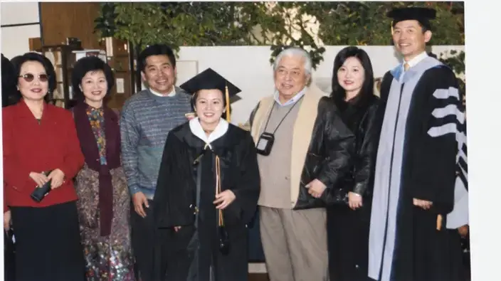 Graduate with family members and College representatives